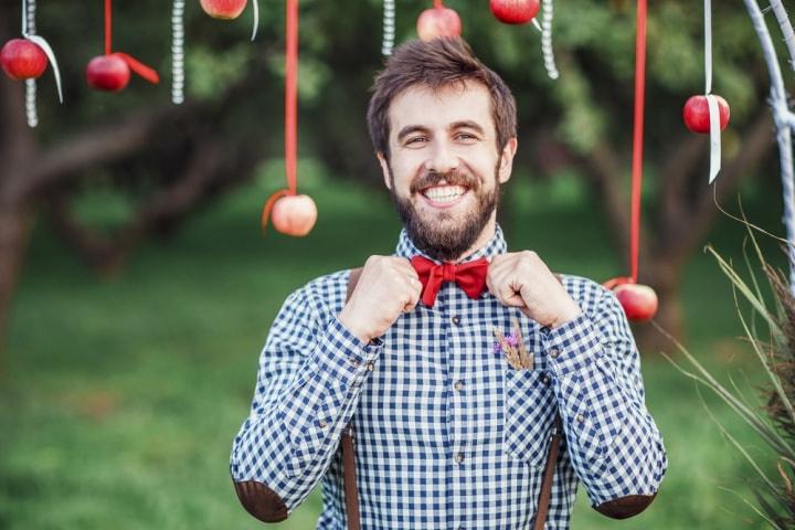 Barbeiro masculino em camisa xadrez penteando o cabelo de um