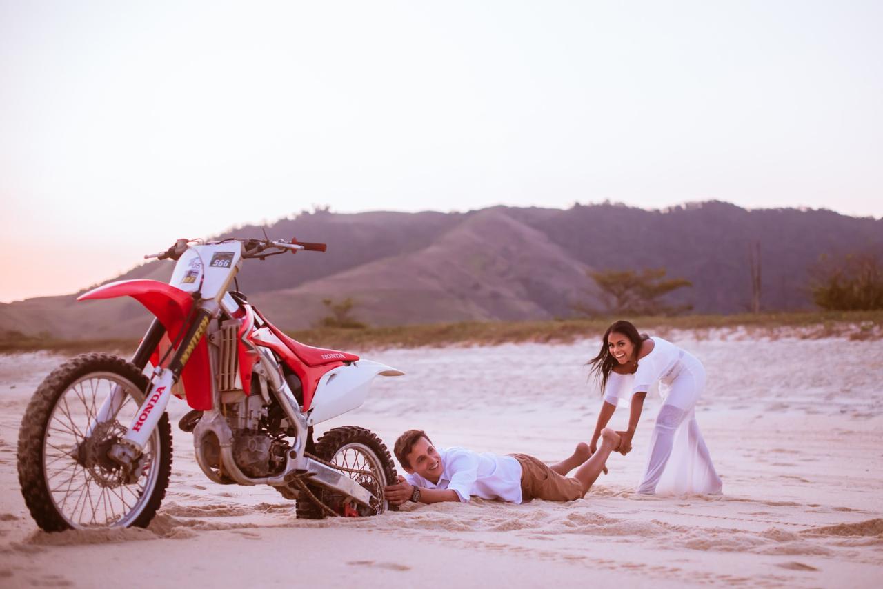 frases para fotos no instagram​ noivo sendo arrastado pela noiva em praia enquanto se segura em moto