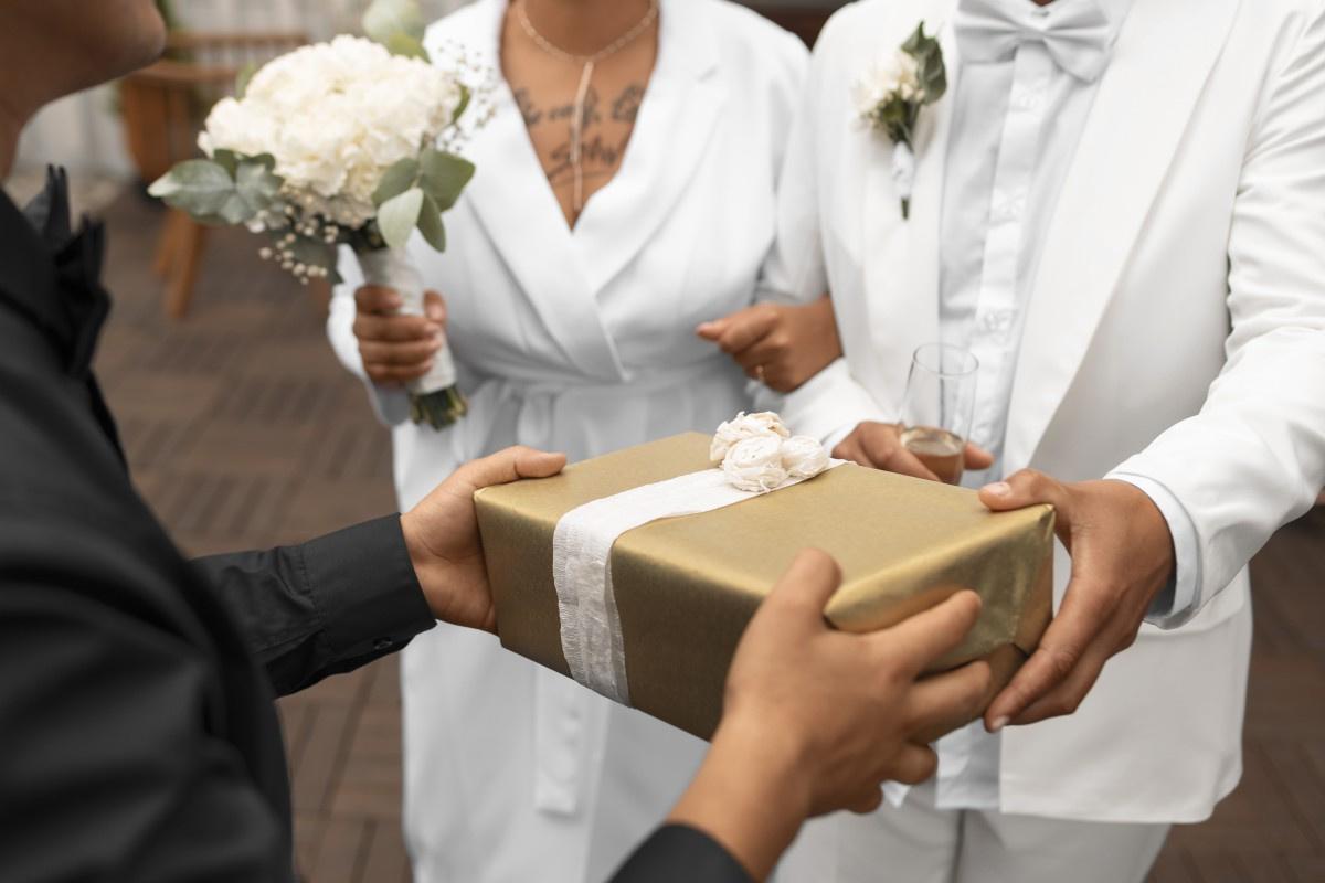 Mensagem para os noivos: noivos recebem presente das mãos de convidado