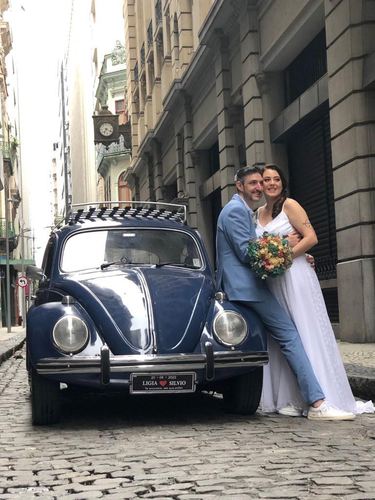 Casal com fusca no casamento