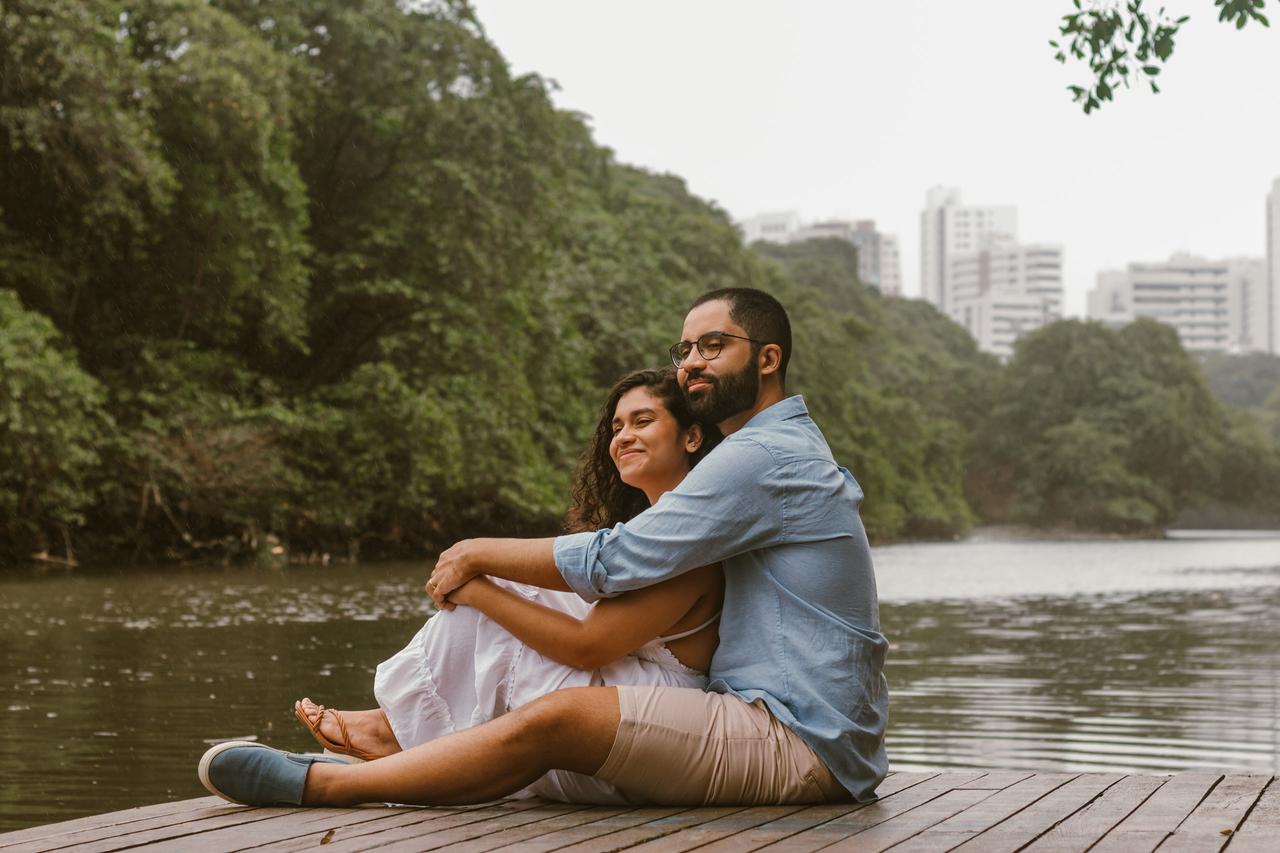 frases para fotos no instagram​ casal sentado em píer olhando o horizonte de tarde
