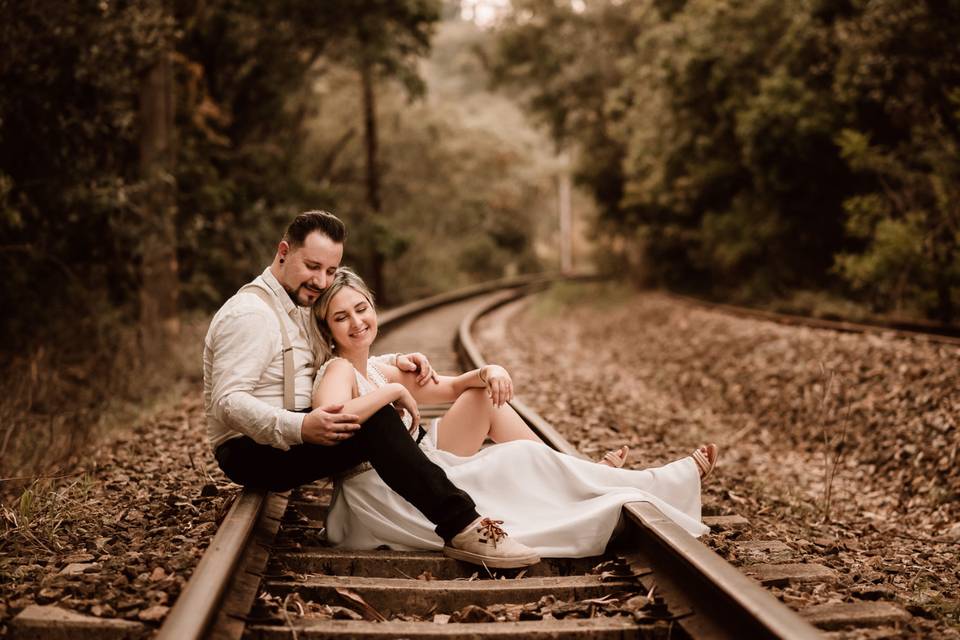 Casal sentados e namorando na trilha do trem