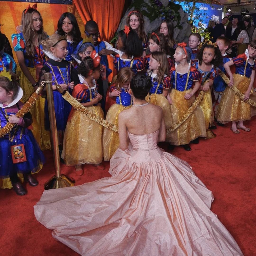 Rachel Zegler ao lado de muitas brancas de neve mirins