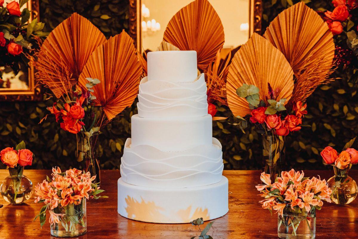 Feminino mão decorando o bolo de aniversário de casamento flor