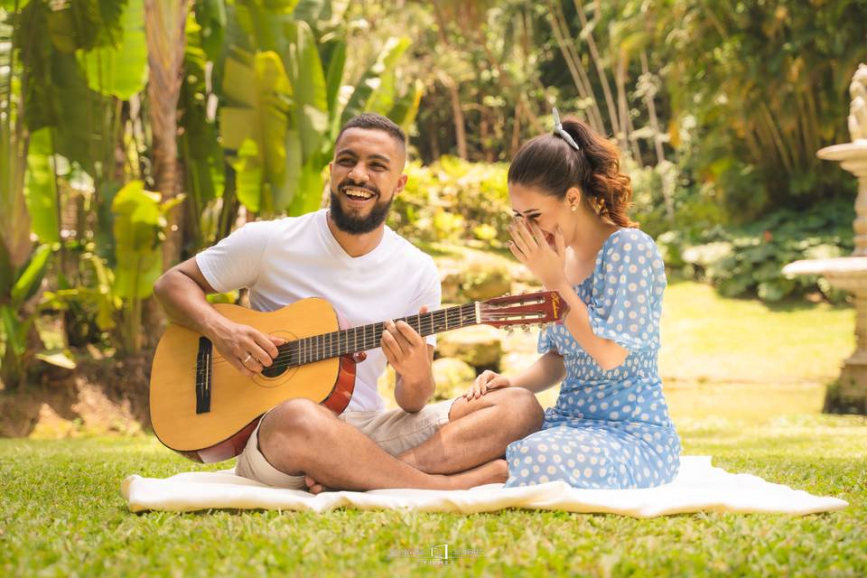 Noivando tocando violão para sua noiva em um jardim