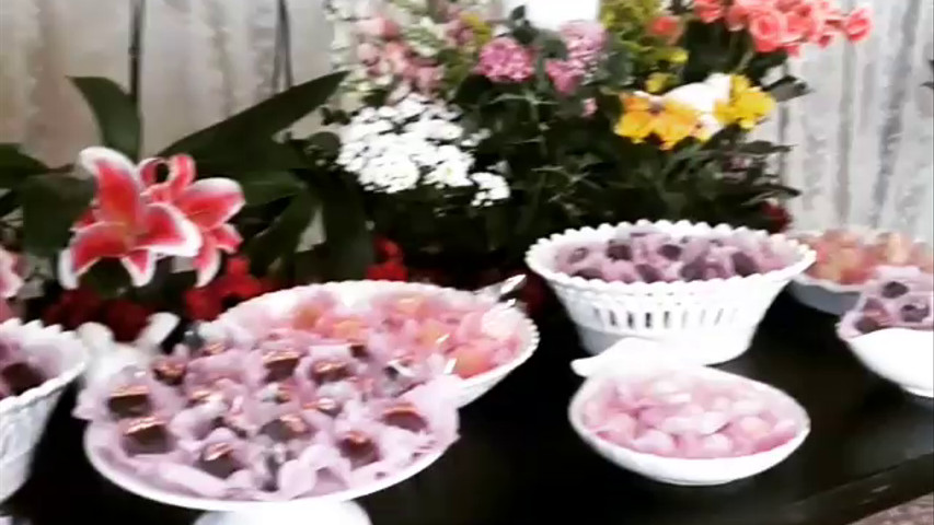 Mesa de doces com decoração de  flores plantadas