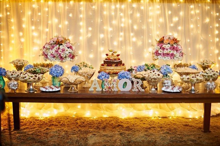 luzes amarelas deixando a mesa de doces ainda mais romântica