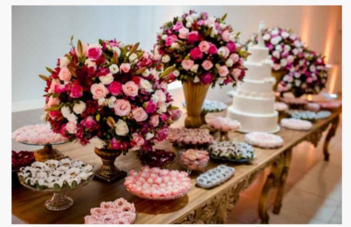Noivinhas, para decoração na paleta do rosa chá com mesa dos doces e do bolo sendo de madeira fica m