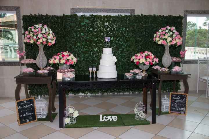 Mesa do bolo, com as flores pink e com quase nada de docinhos