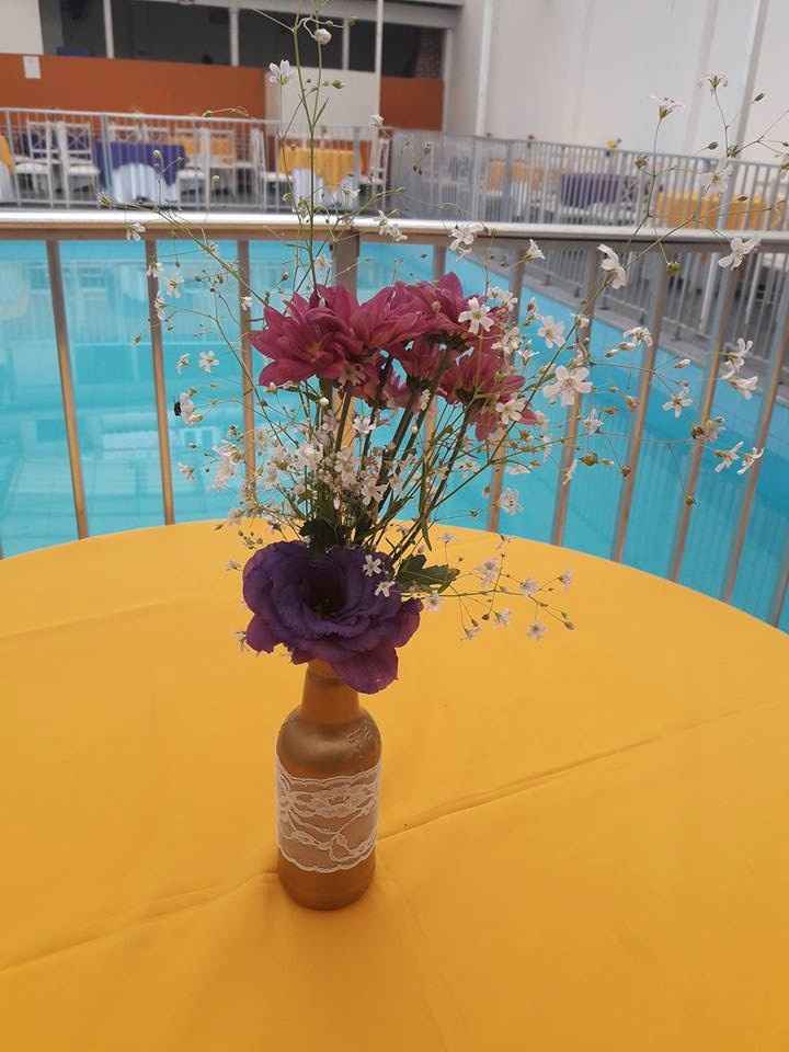 Garrafa pintada de jet dourado, com flores compradas na CADEG