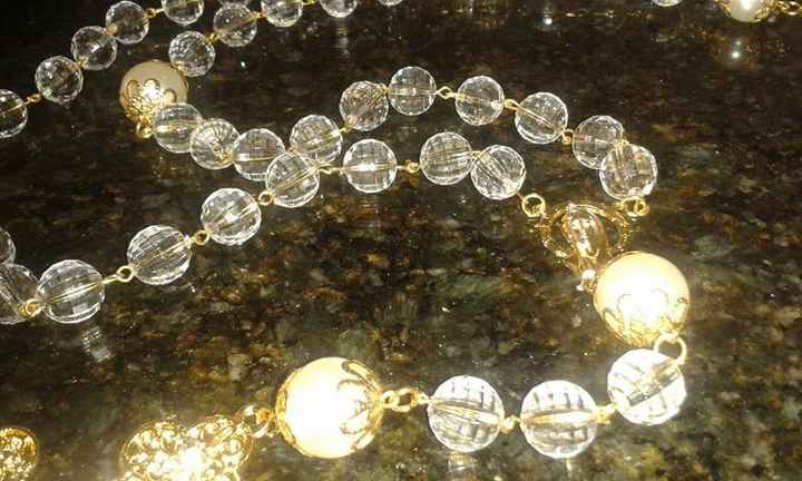 Terço com contas pequenas em bola de cristal, contas grandes em bola de pérola, e tulipas em dourado