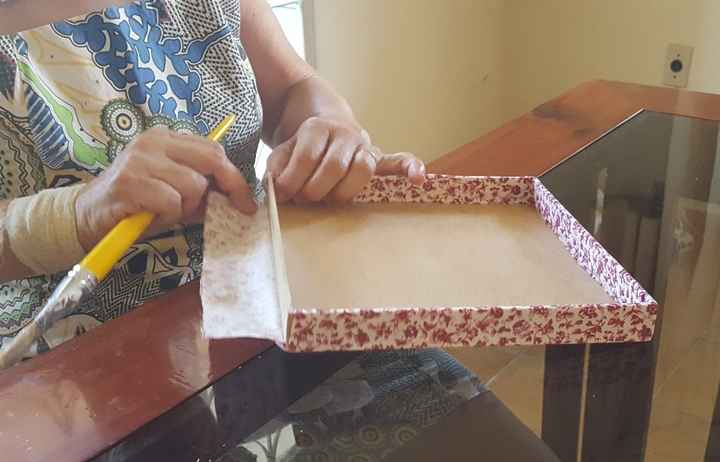 Minha mãe ajudando a forrar as tampas com tecido. ♥