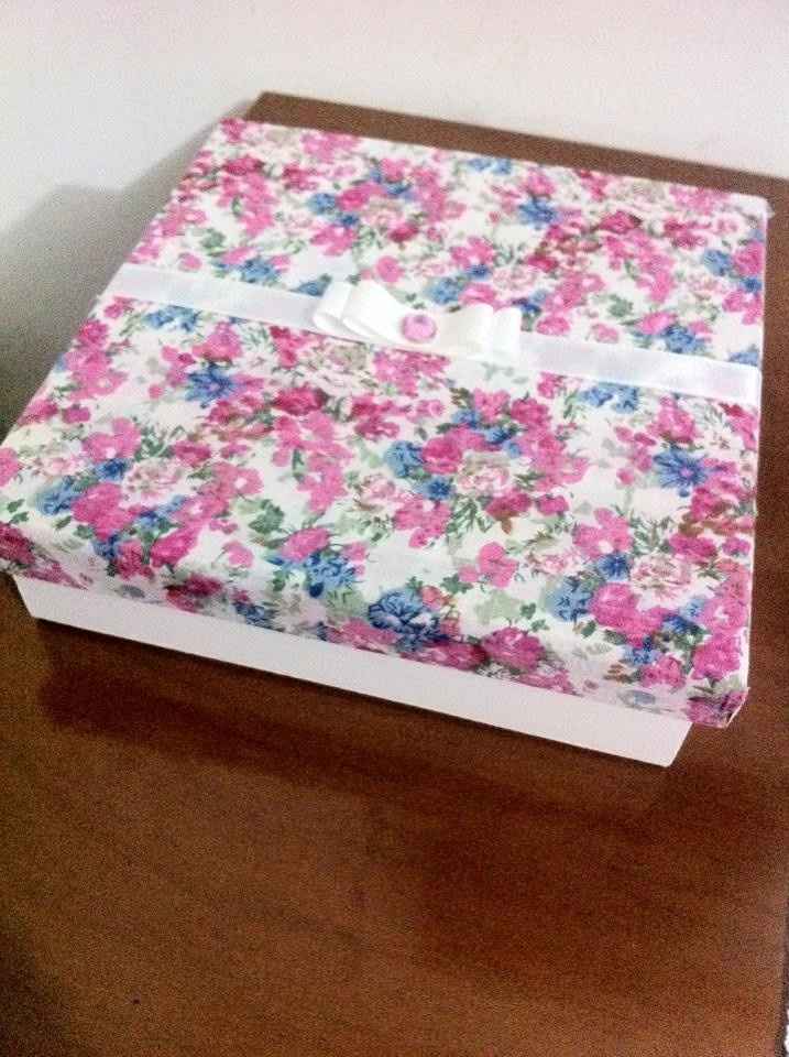 Caixinha pintada na parte de baixo e encapada com tecido na tampa.