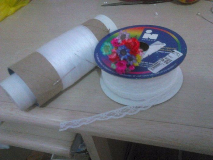 Linha, agulha, flores secas, renda