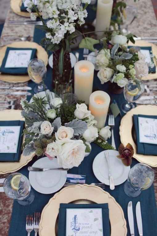 Decoração de casamento azul com velas e flores na mesa