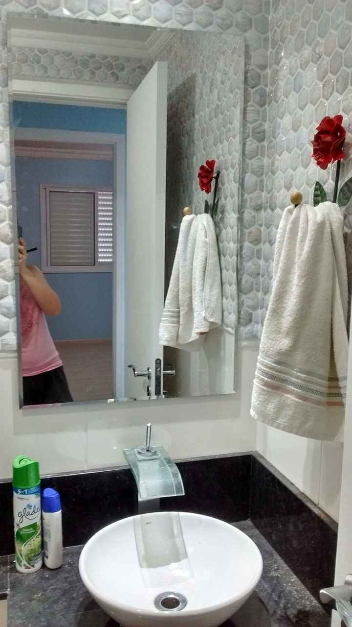 banheiro com espelho e suporte de toalha