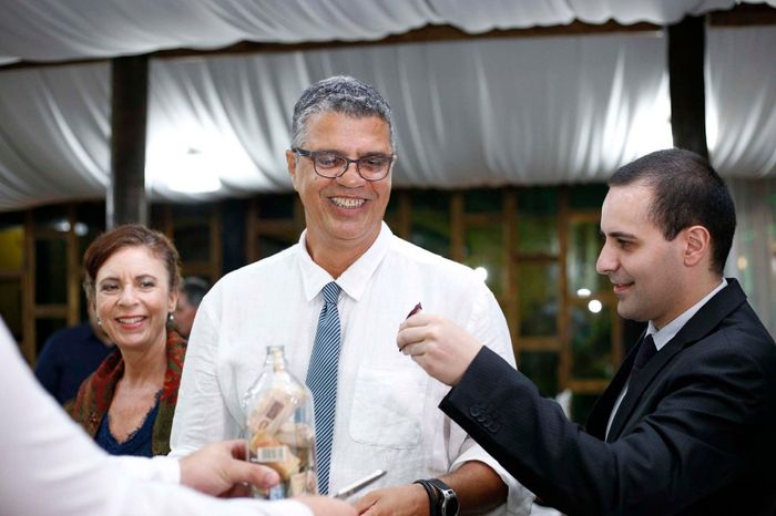 Os homens enchendo a garrafa com o corte da gravata
