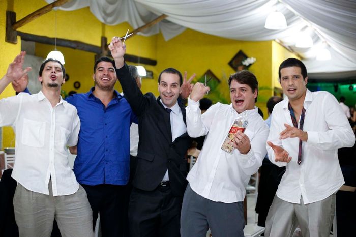 Os homens enchendo a garrafa com o corte da gravata