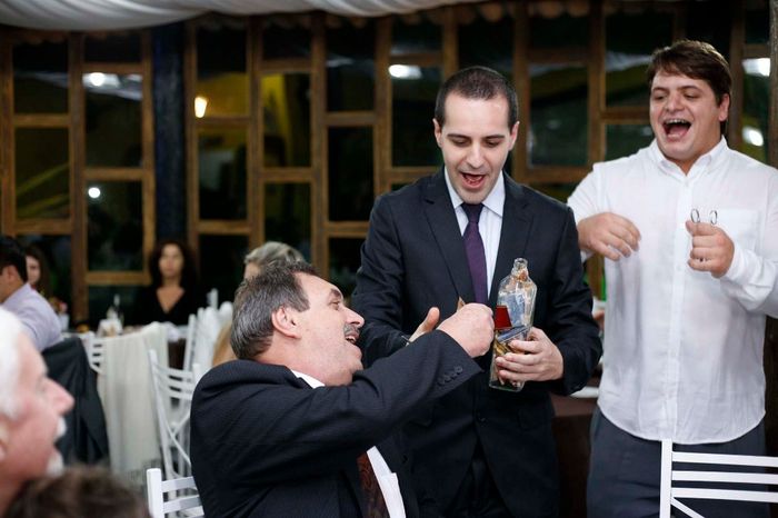 Os homens enchendo a garrafa com o corte da gravata
