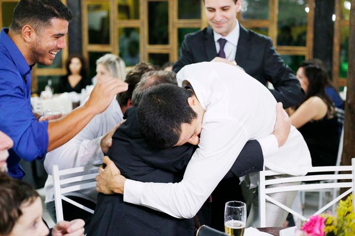 Os homens enchendo a garrafa com o corte da gravata