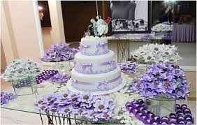 Mesa do bolo de vidro com forminhas florais de docinhos