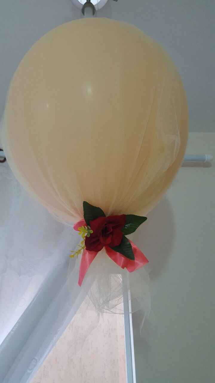 Compramos bolas bem grandes e envolvemos com tule, e amarramos com fita e uma flor falsa.