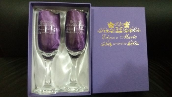 as taças acomodadas num cetim branco e toalhinhas de cetim roxa