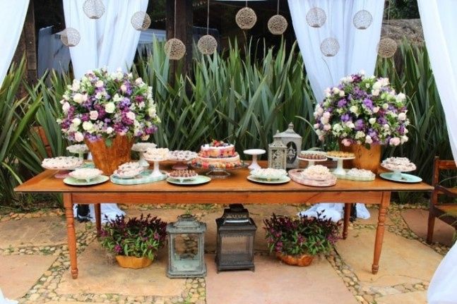 a mesa do bolo com arranjos e doces fica bem mas o bolo ele tá muito baixo  eu como cerimonialista e