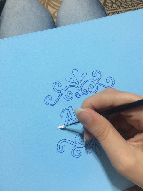Pintando com pincel fino o desenho e as inicias