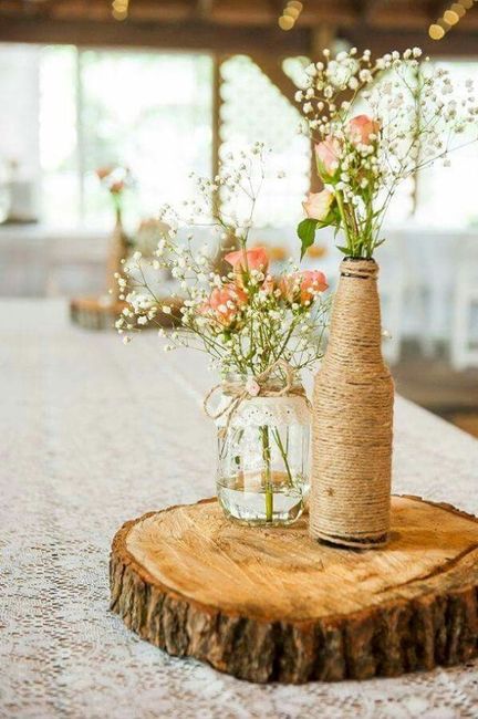 centro de mesa com garrafas e potes com flores 
