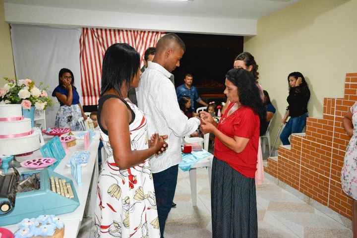 Minha mãe colocando a aliança no dedo dele.