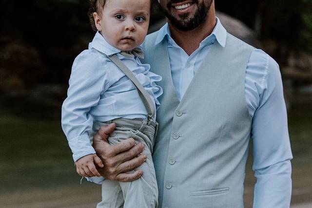 Noivo segurando bebê no colo durante ensaio fotográfico de casamento ao ar livre