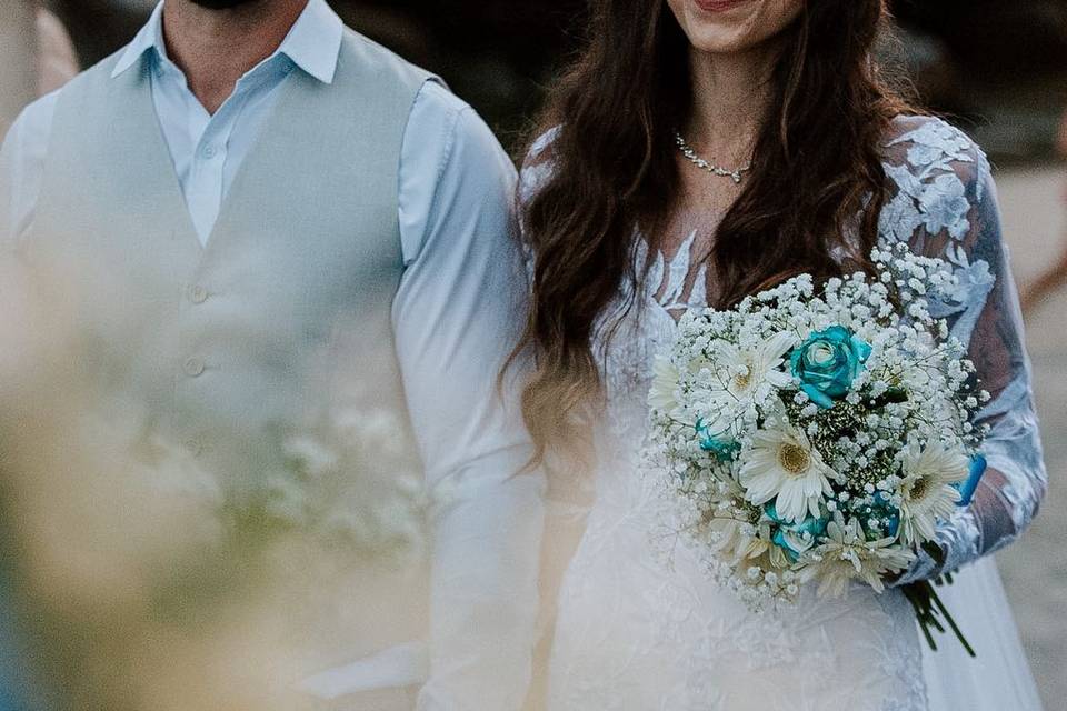 Detalhe do buquê da noiva com flores brancas e azuis em fotografia artística de casamento