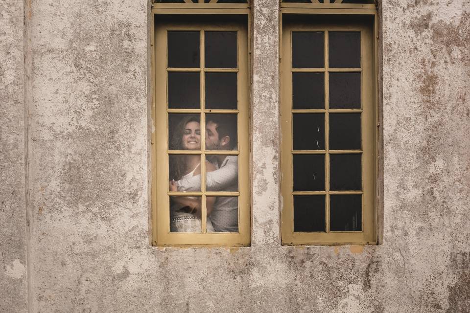 Casal abraçado na janela