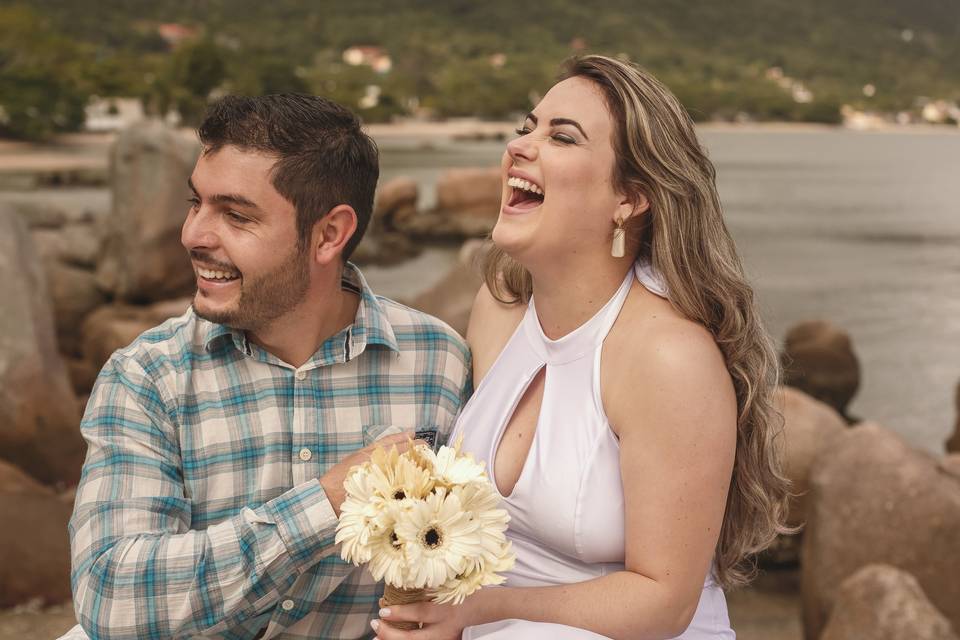 Casal sorrindo sobre as pedras