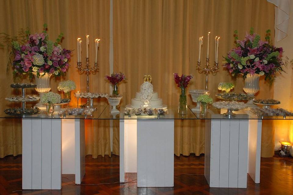 Mesa de bolo e doces decorada com flores