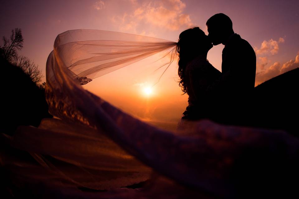 Véu e beijo ao por do sol