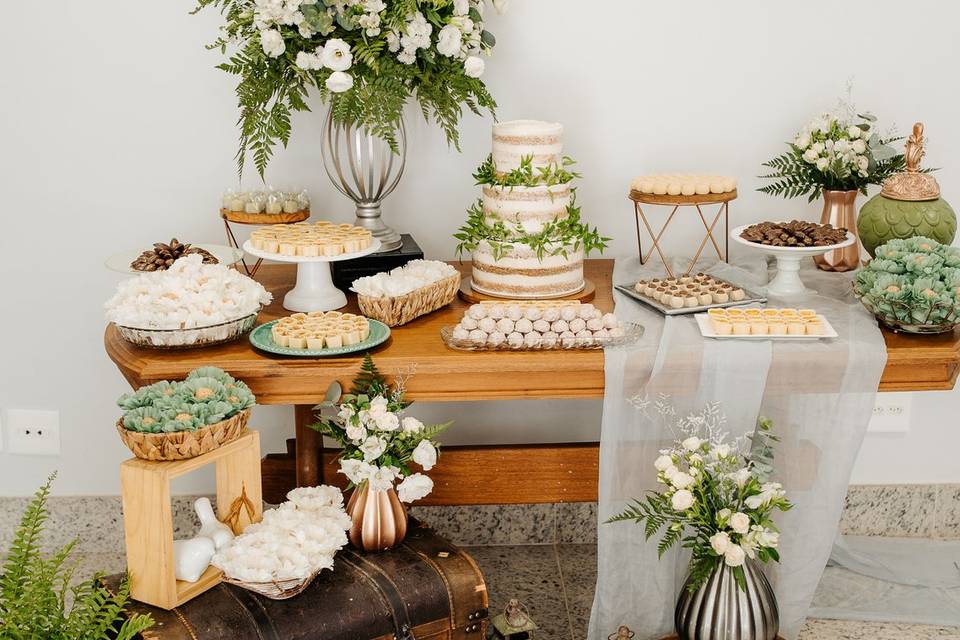 Mesa com doces e bolo de andar