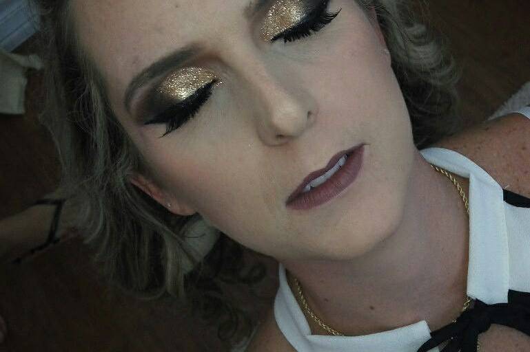 Maquiagem com glitter dourado.