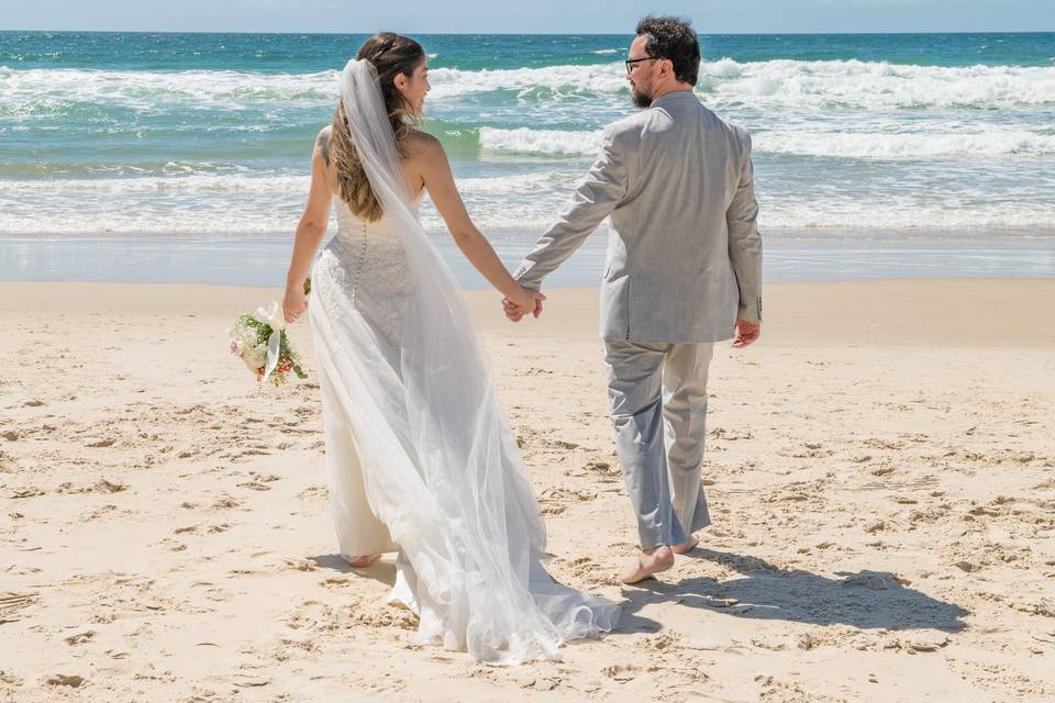 Noivos caminhando na praia