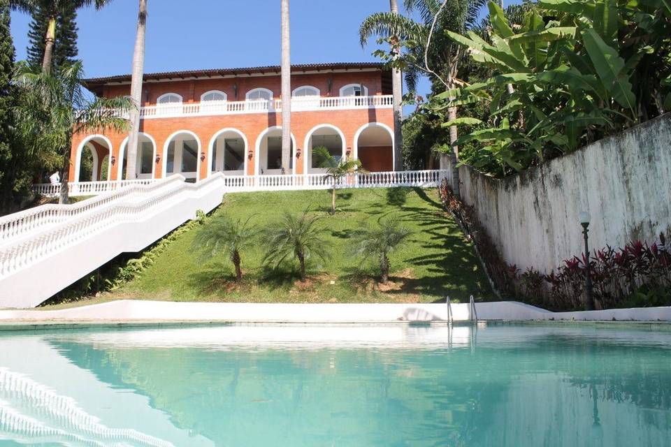 Vista da mansão pela piscina